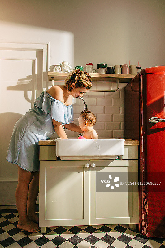 在厨房水槽里给婴儿洗澡图片素材
