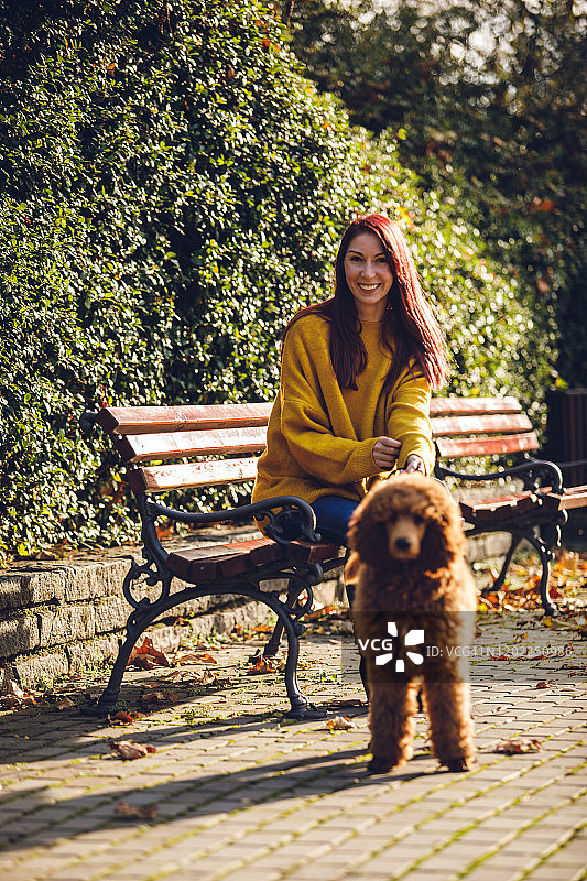 快乐的女人和她的狗在公园里图片素材