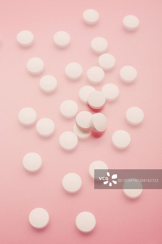 高角度的白色药丸在粉红色的背景图片素材