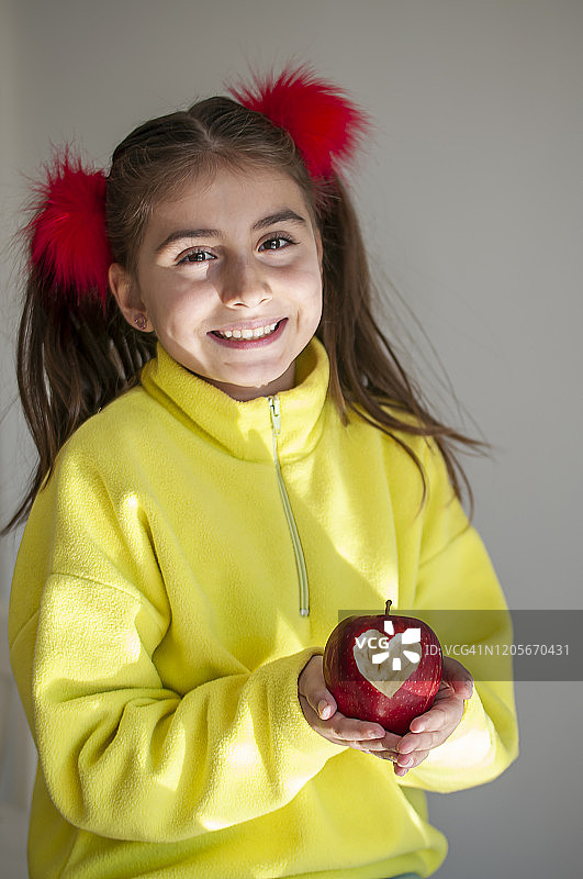 女孩手里拿着红色的心形苹果图片素材
