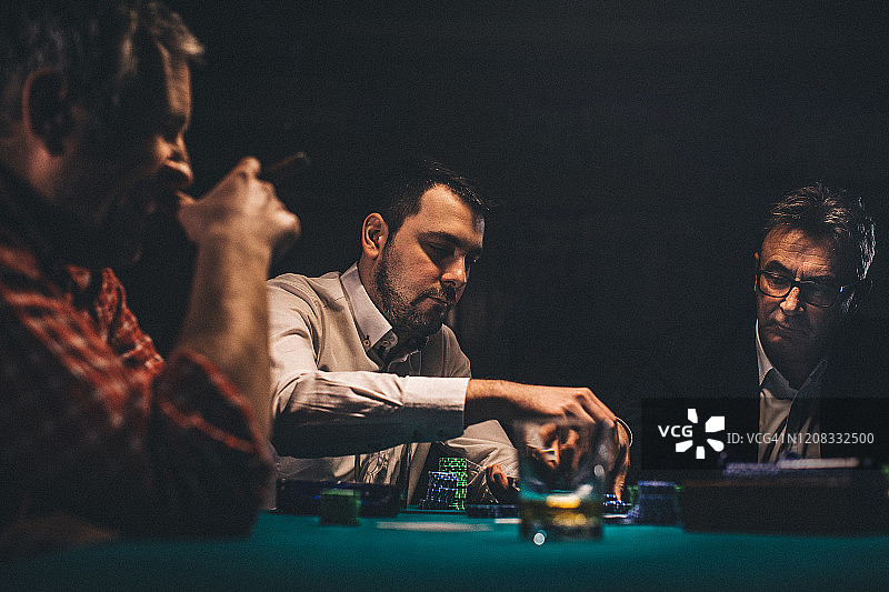 男人晚上在暗室里打扑克图片素材