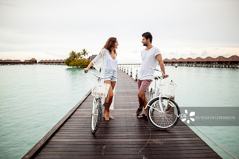 一对夫妇在马尔代夫Gaafu Dhaalu环礁Maguhdhuvaa岛的海上码头上骑着自行车图片素材