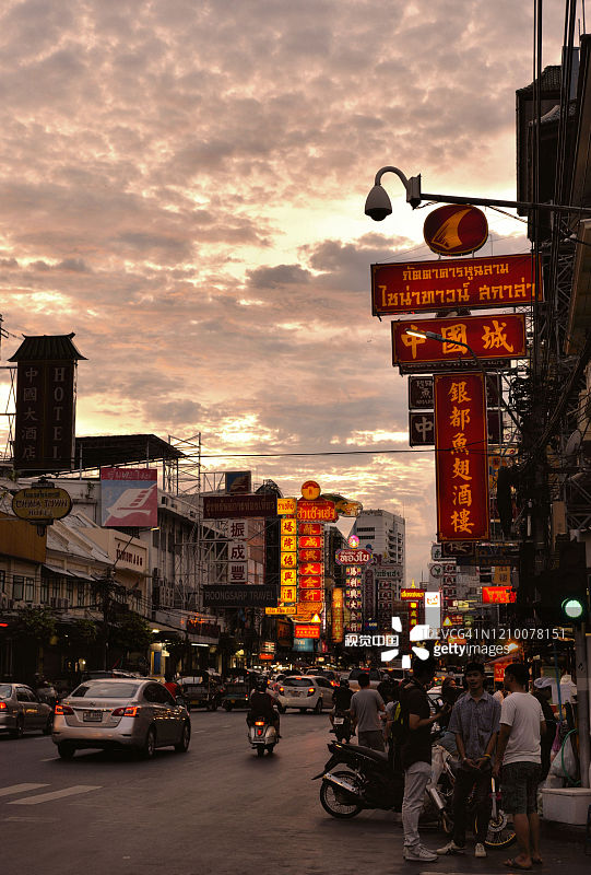 泰国曼谷唐人街瑶华路上的人们、汽车和商店。日落时分，繁华街道上有著名的中国建筑、餐馆和装饰的唐人街。图片素材