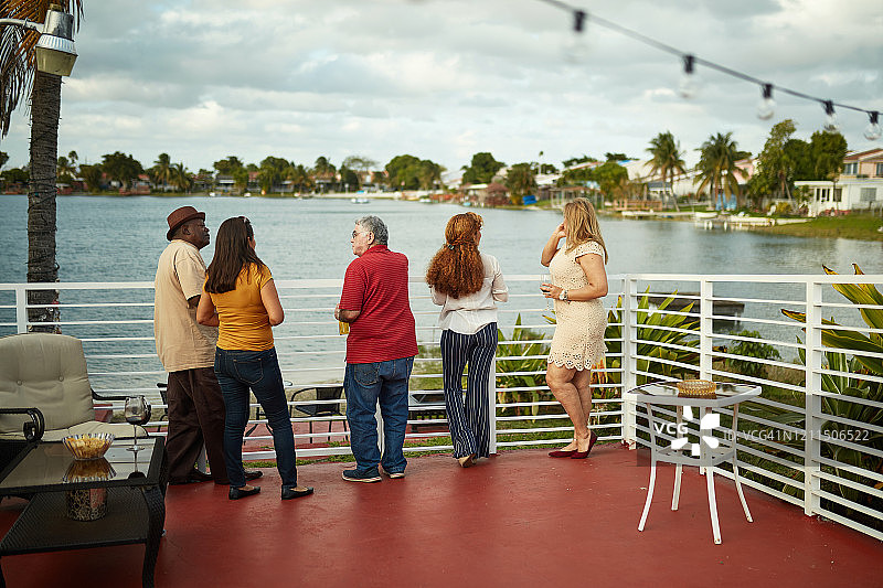 朋友们在佛罗里达的阳台上聊天和看风景图片素材