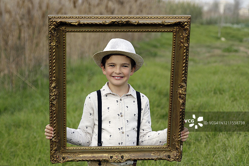 男孩的肖像透过画框看图片素材