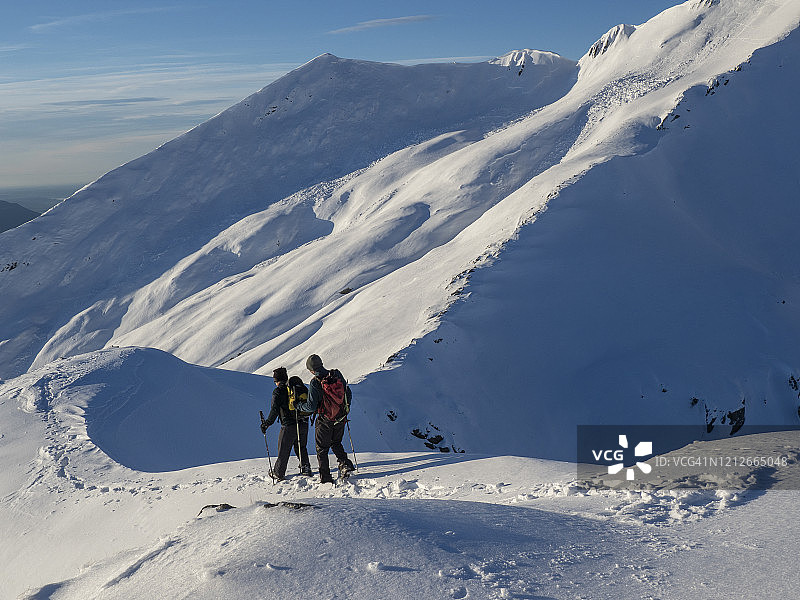登山者从积雪的山脊上下来图片素材