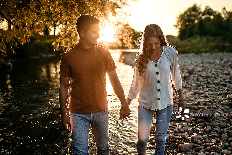 顽皮的年轻夫妇在河边散步图片素材