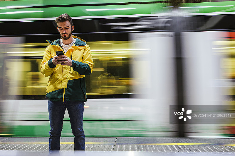 一名男子在地铁站使用手机图片素材