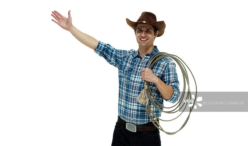 白人年轻男性牛仔戴着帽子，手持套索，用绳子站在白色背景前图片素材