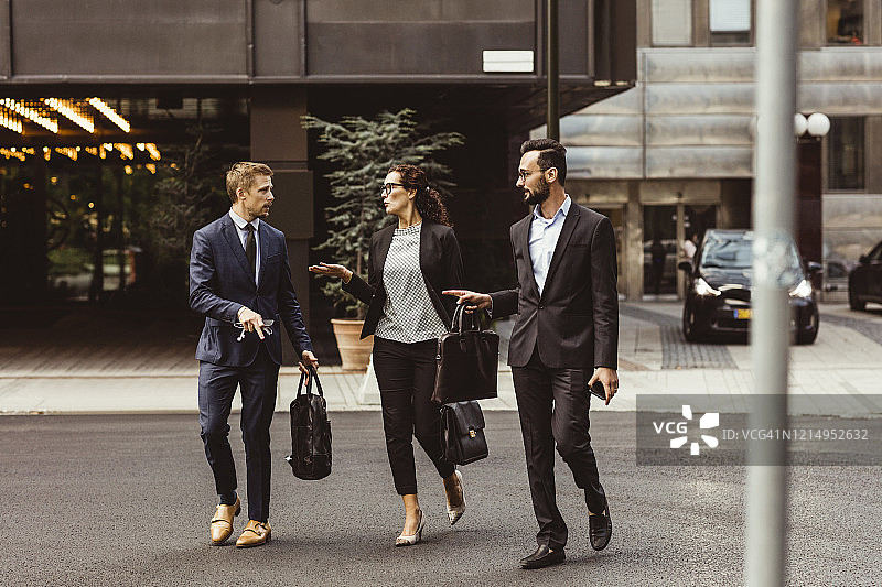 男性和女性企业家在户外散步时讨论商业策略图片素材