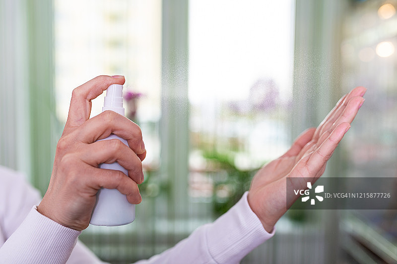 白人妇女用含酒精的洗手喷雾擦手。抗菌洗手液凝胶预防冠状病毒(Sars-CoV-2、Covid-19)感染的措施。图片素材