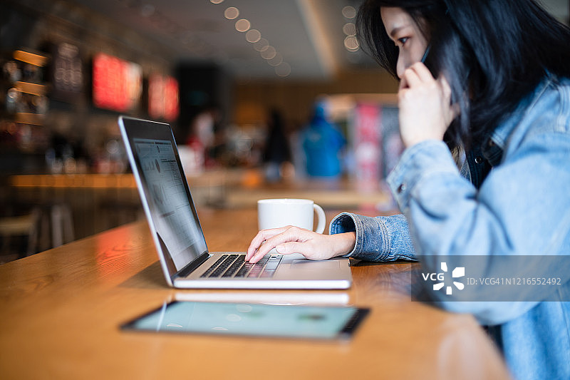 亚洲女性在咖啡馆使用笔记本电脑图片素材
