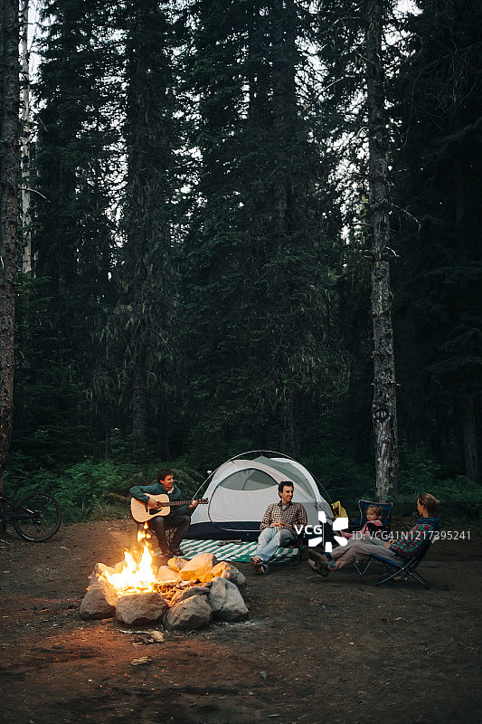 在俄勒冈州露营时，一群朋友围坐在篝火旁。图片素材
