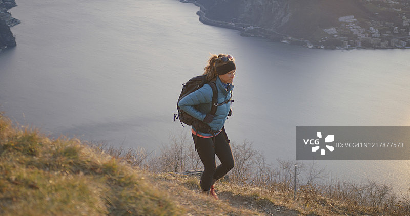 女性徒步旅行者在湖泊和欧洲阿尔卑斯山上行走图片素材
