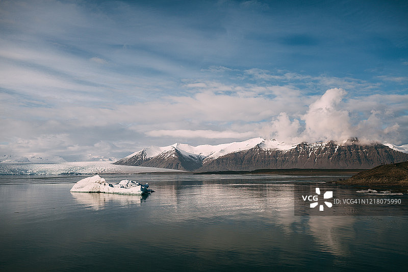 在阳光明媚的冬日，冰岛雪山前的冰川泻湖图片素材