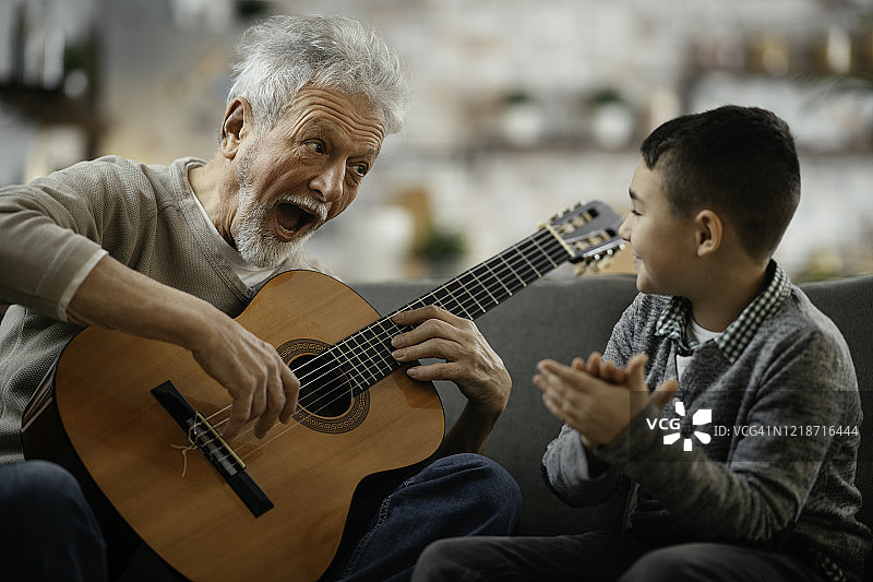 爷爷和孙子在弹吉他。图片素材