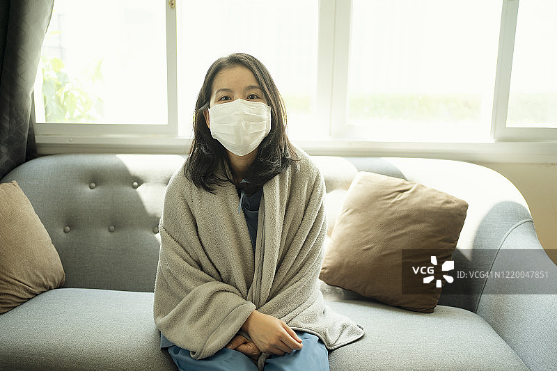 亚洲女性在家里玩游戏，防止新冠病毒(冠状病毒)传播，并在家工作14天图片素材