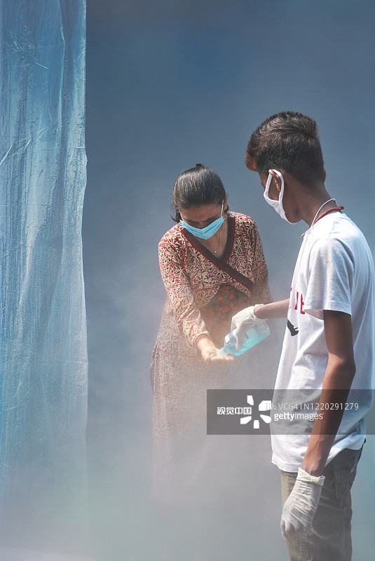 在封锁期间，加尔各答的一个市场里的人们正在被消毒图片素材