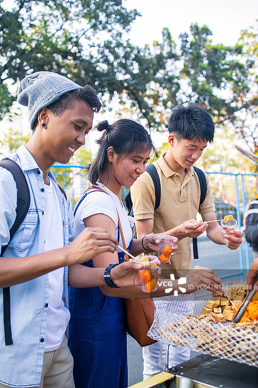 年轻的亚洲朋友选择街头小吃图片素材