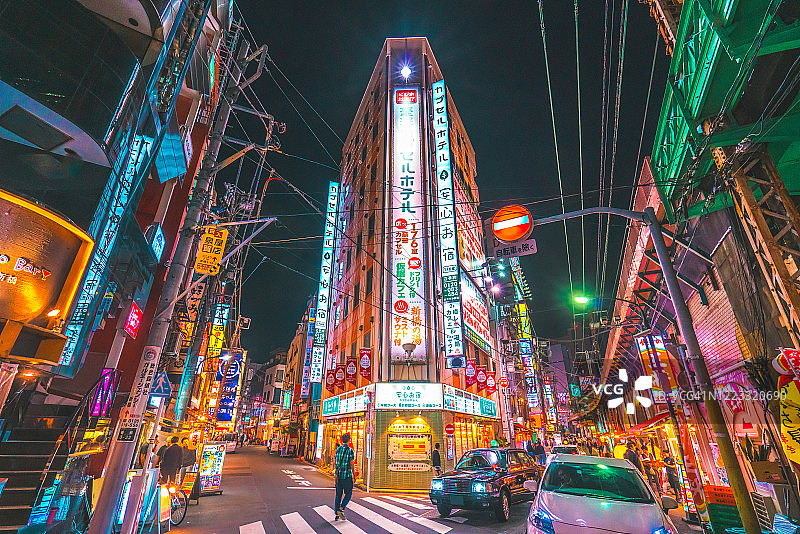东京高峰时段的通勤者在日本新桥的街道上霓虹闪烁图片素材
