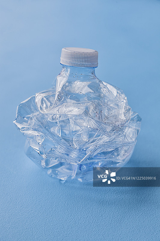 粉碎的塑料瓶在蓝色背景上回收图片素材