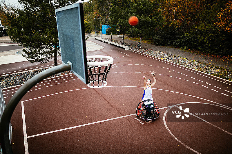 妇女在轮椅打篮球和得分-残疾运动和娱乐图片素材