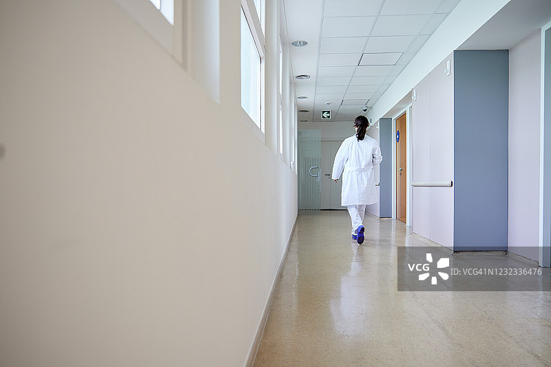 一位女医生走在医院的走廊上图片素材
