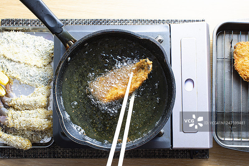 日式家常菜食谱，炸马鲛鱼和炸虾。他们在油里煎鲭鱼。图片素材