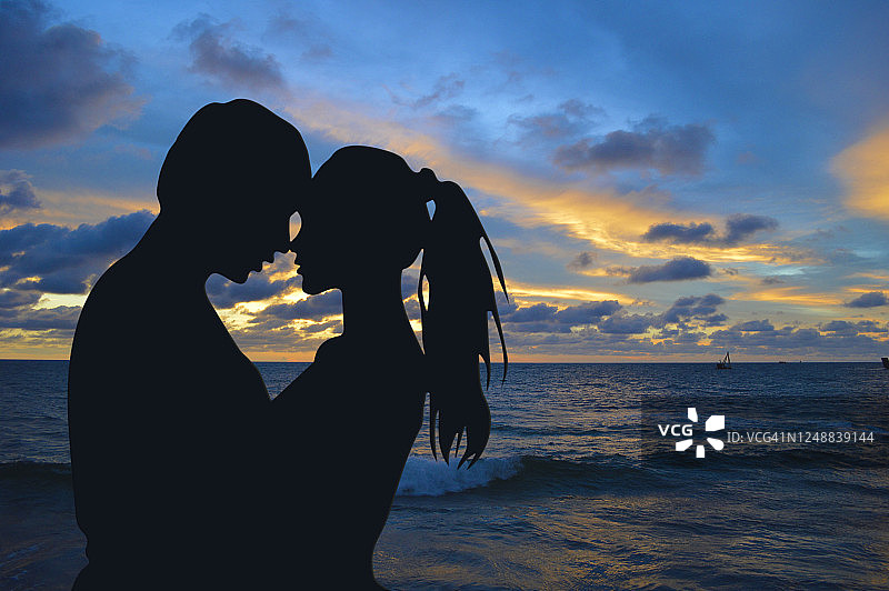 一对年轻夫妇在海边拥抱图片素材