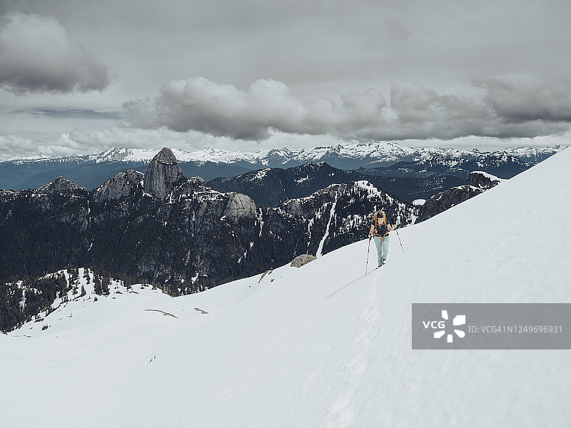 女登山者徒步穿越BC海岸山脉的雪坡高图片素材
