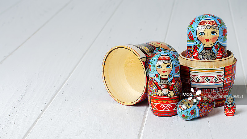 五个红色的套娃。传统的俄罗斯玩具。副本的空间。白色木制背景图片素材
