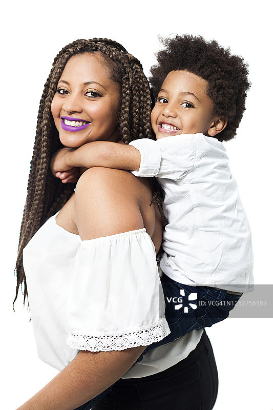 美丽的黑人单身妈妈背着她的儿子，两人对着镜头微笑图片素材