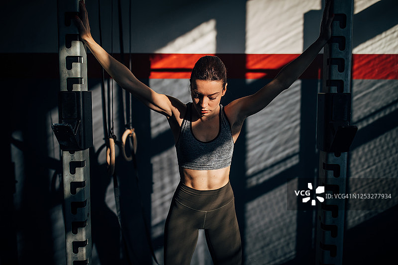 一个年轻健康的女人独自站在健身房图片素材