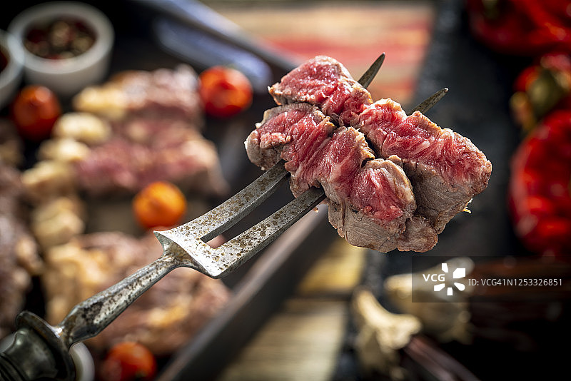 切肉牛肉条牛排肉宏与复古切肉叉和酱汁图片素材