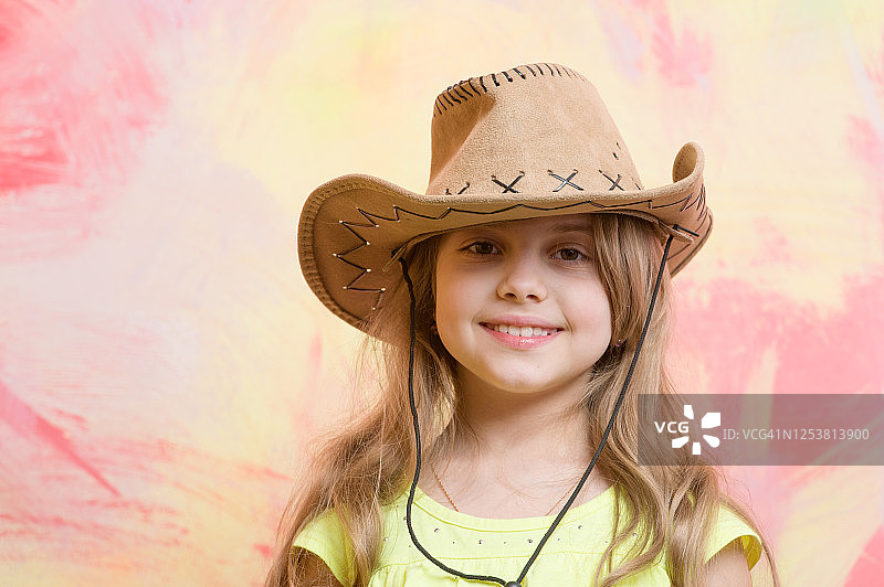 小女孩在彩色的背景牛仔帽，复制空间图片素材