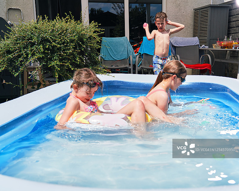 后院水好玩可爱的小孩在游泳池里玩图片素材