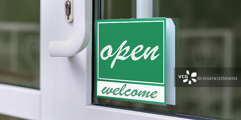 在绿色和白色的店门或餐厅门框上打开欢迎标语图片素材