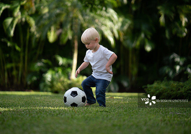 一个小男孩在玩足球图片素材