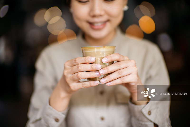 一个亚洲的中国女人在咖啡厅里享受咖啡图片素材