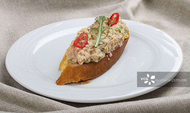 白盘子上的意式烤面包和鞑靼鱼，以纺织品为背景图片素材