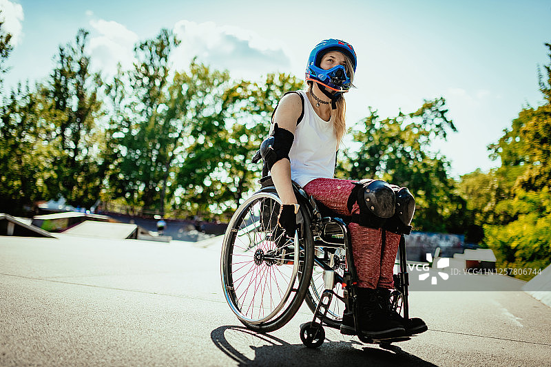 坐在轮椅上的残疾妇女在滑板公园表演特技图片素材