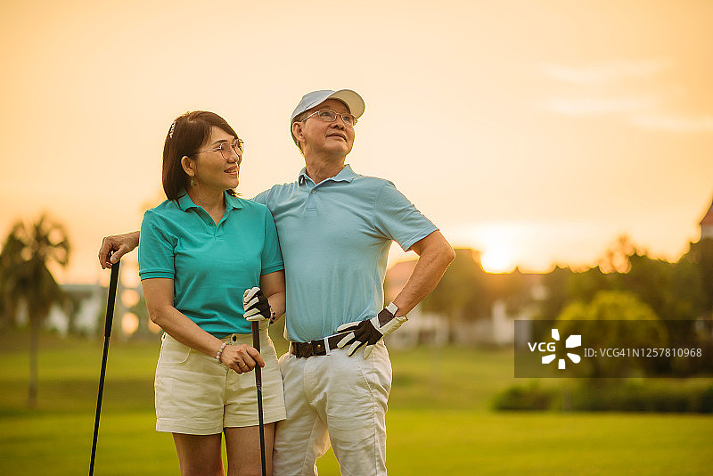 亚洲华人活跃的老夫妇微笑高尔夫球享受一天的高尔夫球场图片素材