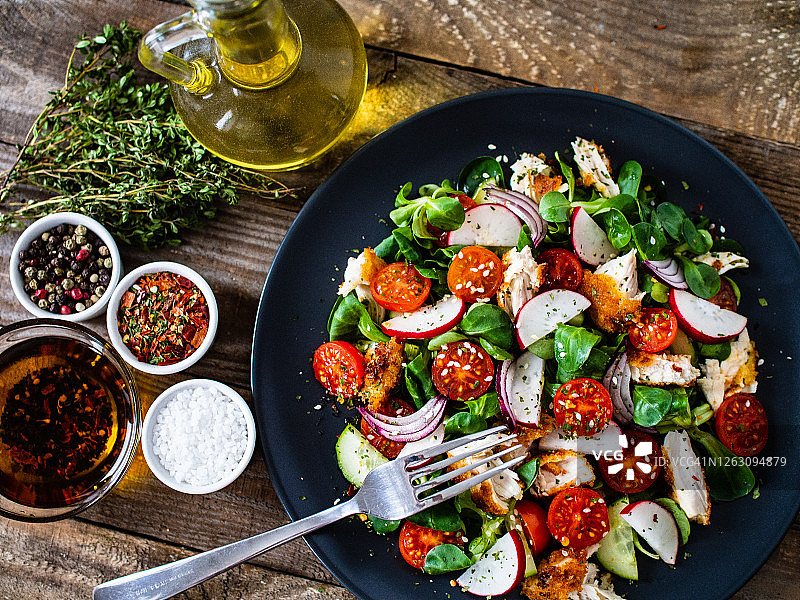 凯撒沙拉-蔬菜沙拉与烤鸡肉在木背景图片素材