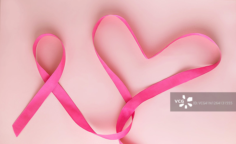 粉红色的丝带和粉红色的心形作为女性乳房疾病的象征。乳腺癌宣传月。简约的风格。前视图。些lei。文本。副本的空间。图片素材