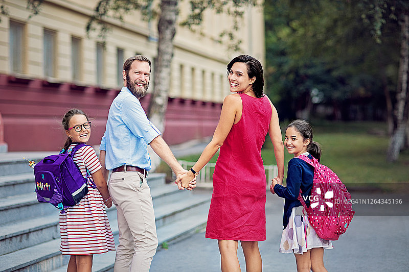 幸福的家庭走在学校的前面图片素材