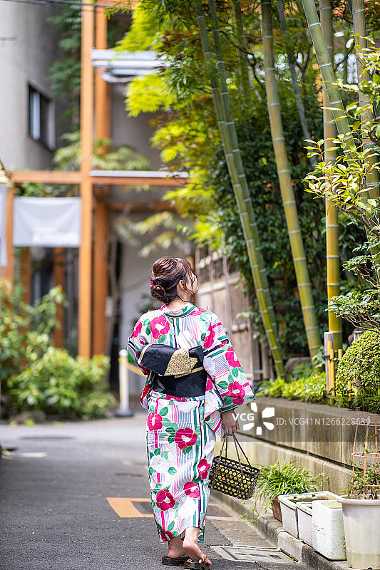 年轻女子在浴田参观一个古老的日本城镇图片素材