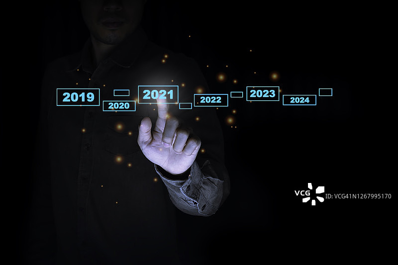 2020-2021年，商人触摸虚拟屏幕。欢迎2021年概念图片素材