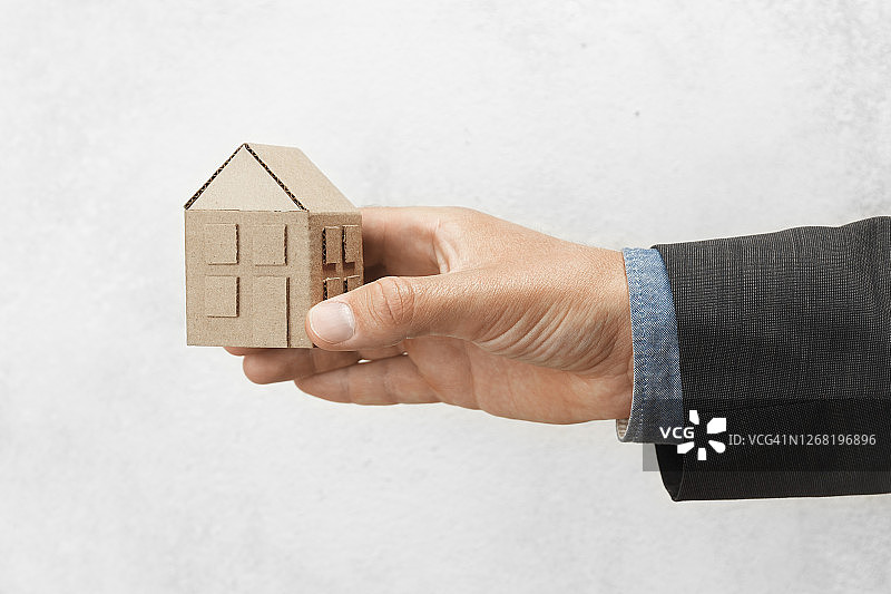 手握着房子。买卖房屋，房地产保险。保护与安全寿命图片素材