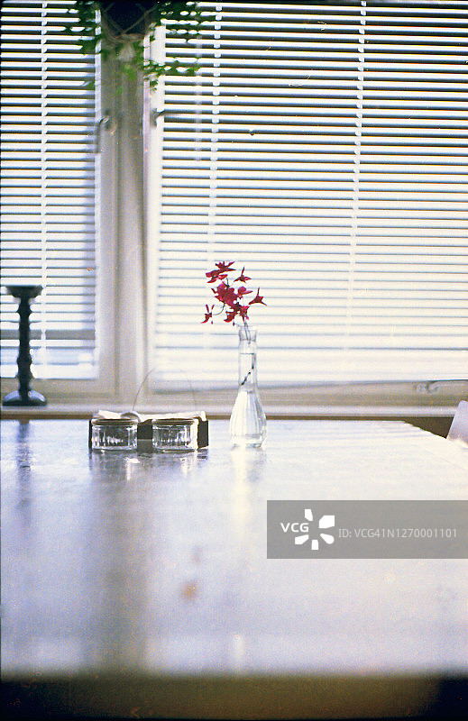 窗边餐桌上花瓶里的紫色兰花图片素材