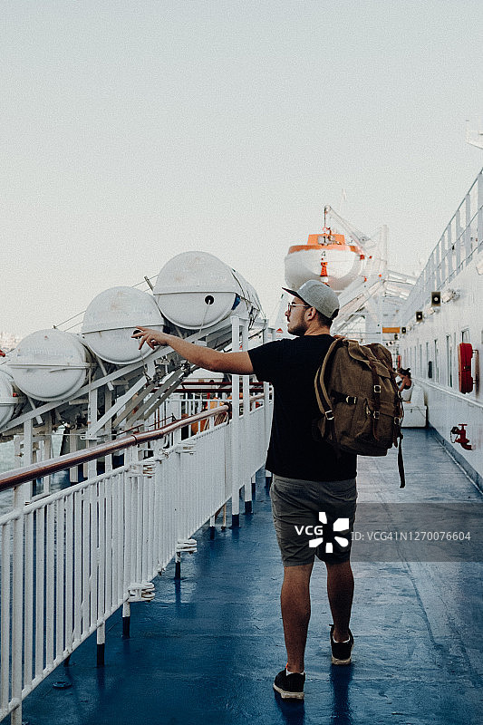 一个男人站在渡轮甲板上望向大海的肖像图片素材